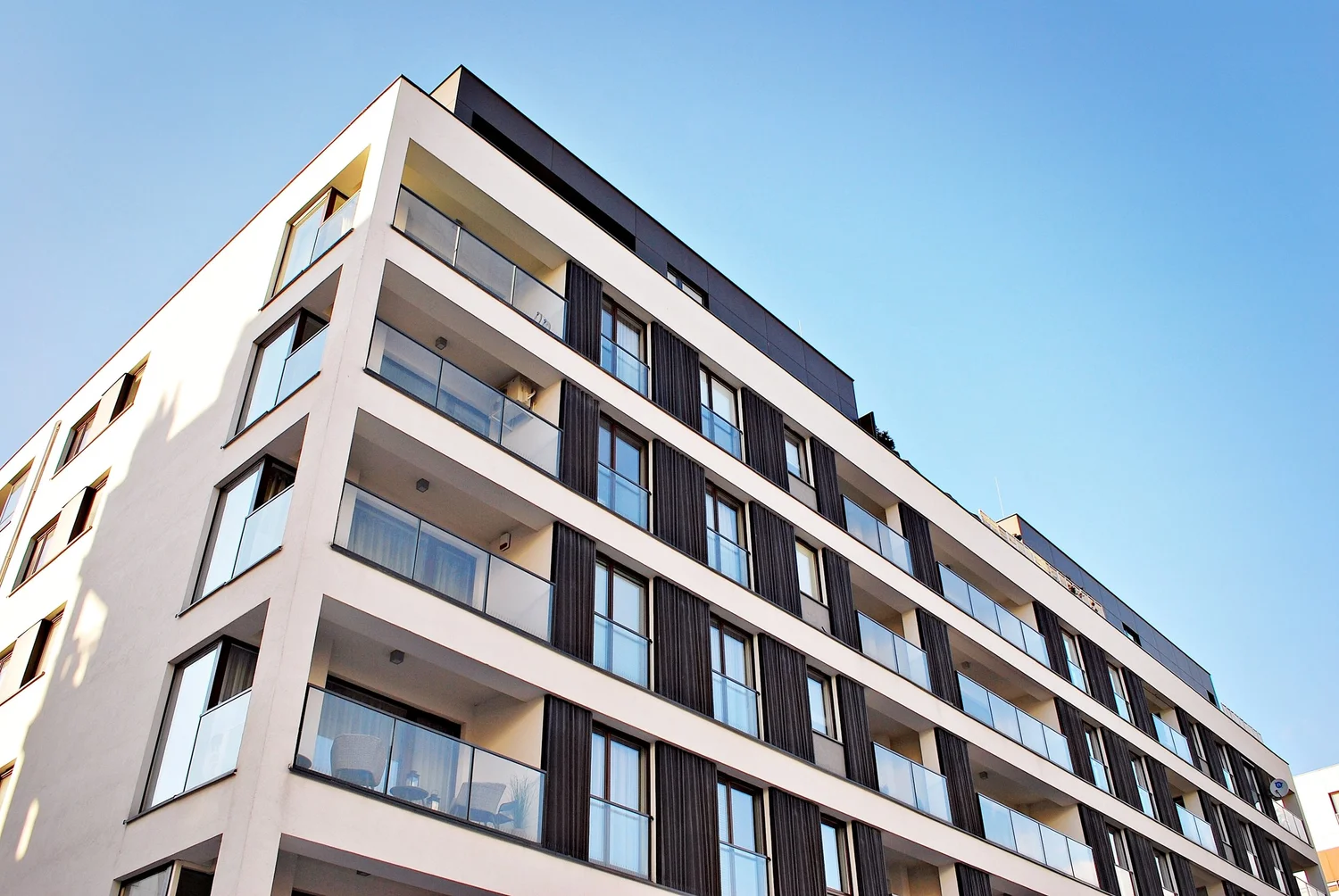 A modern multifamily building with glass balconies